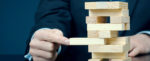 Close up of business man's hands playing a game of jenga